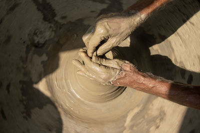 Cropped image of person making pottery wheel