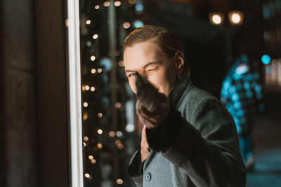 Portrait of woman looking at illuminated christmas lights