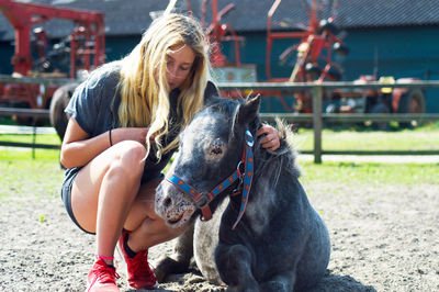 Rear view of woman petting pony