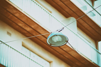 Low angle view of hanging light against railings