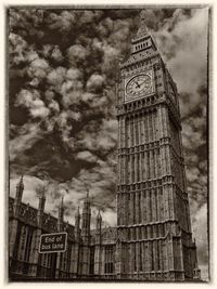 Low angle view of clock tower against cloudy sky