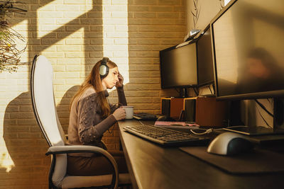 Portrait of young woman using laptop on table