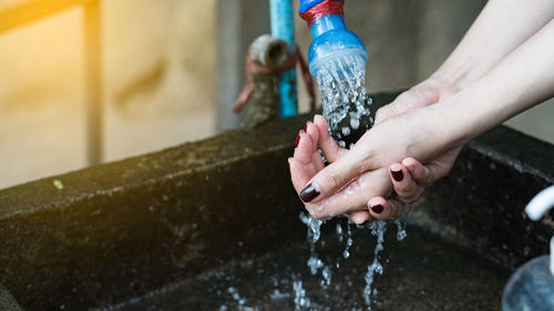 Cropped image of woman washing hands