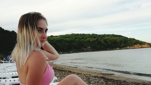 Portrait of beautiful woman on land against sky