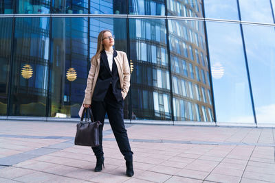 Successful happy business woman with bag over office building background person