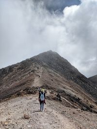 Rear view of man on mountain against sky