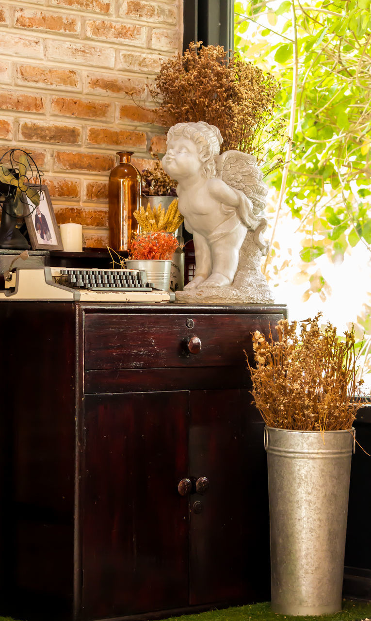 STATUE OF WOMAN WITH POTTED PLANT