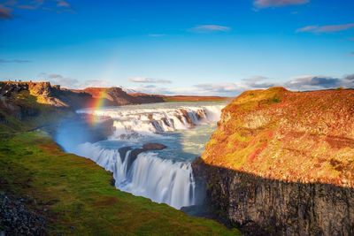 Scenic view of waterfall against sky