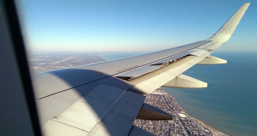 Aerial view of airplane wing against clear blue sky