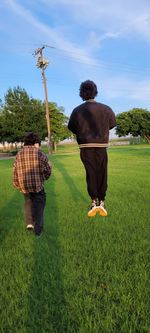 Rear view of men sitting on field