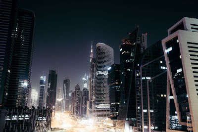 Low angle view of illuminated buildings against sky at night