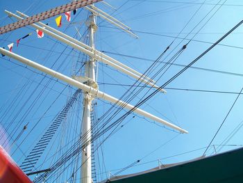 Low angle view of electricity pylon against blue sky