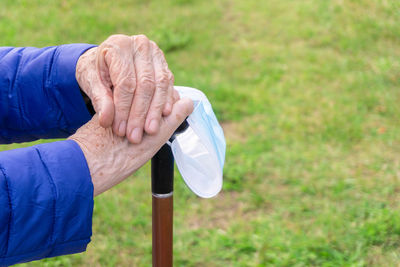 Midsection of man holding hands on grass