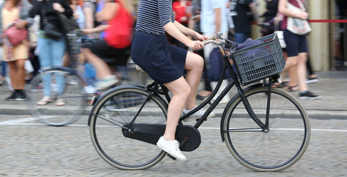 Low section of woman with bicycle on street