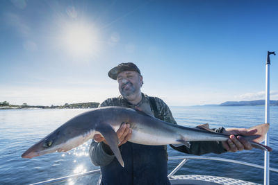 Man on boat holding fish