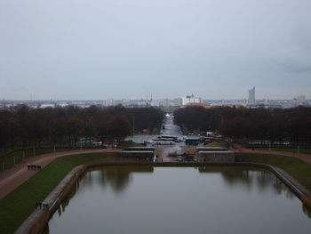 Bridge over river in city against sky