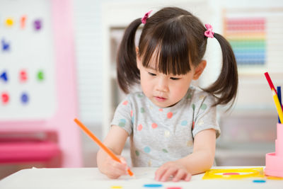 Young girl drawing different shape for home schooling 