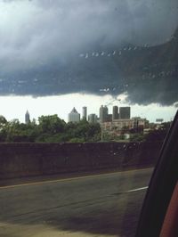 View of cityscape against cloudy sky