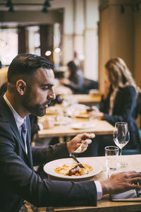 Side view of a man having food in restaurant