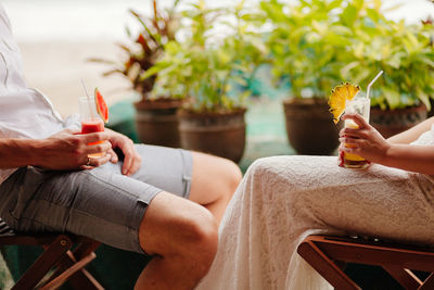 Midsection of man and woman holding drink in glass