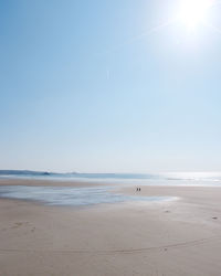 Scenic view of beach against clear blue sky