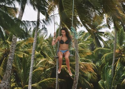 Woman standing on tree trunk