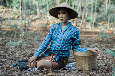 Mid adult man wearing hat sitting in basket