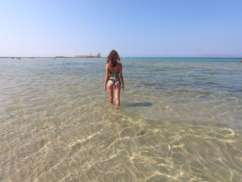 Full length of woman on beach against sky