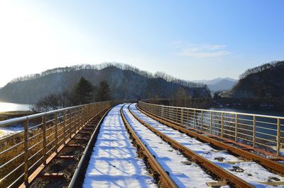 Railroad tracks against sky during winter