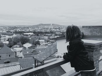 Rear view of man in town against sky