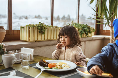 Smiling friends having food at restaurant