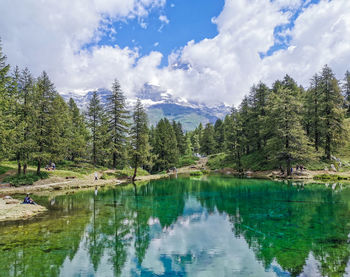 Scenic view of lake by trees against sky