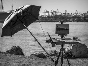 Painted canvas by umbrella in front of river