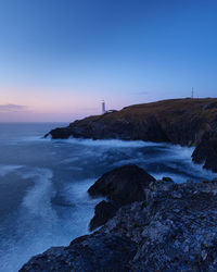 Scenic view of lighthouse at sunset on cornwall coastline 