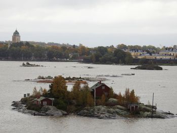 Scenic view of river by buildings against sky