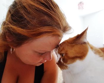 Close-up of young woman with cat with eyes closed