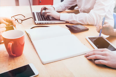 Midsection of man using laptop on table