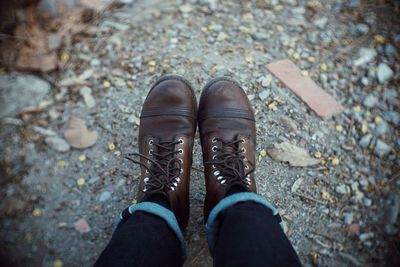 Low section of person wearing boot on land