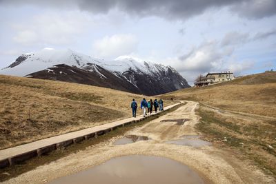 People walking on road against sky