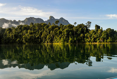 Scenic view of lake by trees against sky