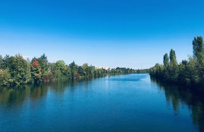 Scenic view of lake against clear blue sky