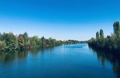 Scenic view of lake against clear blue sky