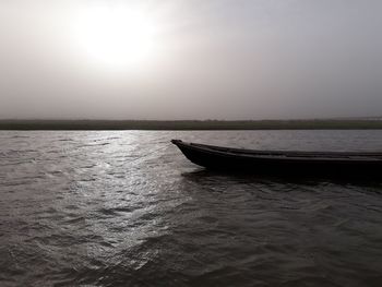 Boat in sea against sky during sunset
