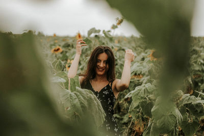 Young woman standing at sunflower farm