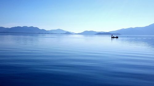 Scenic view of lake against clear blue sky