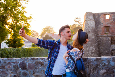 Young couple kissing against sky