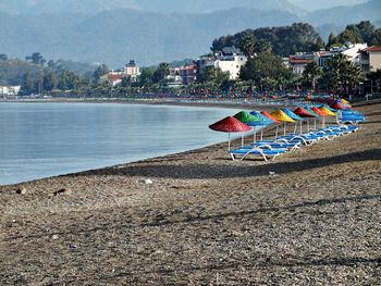 Row of colorful parasols with deck chairs on shore at beach