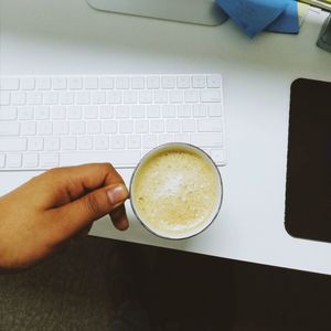 Hand holding coffee cup on table