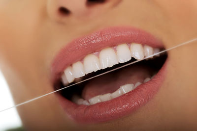 Close-up midsection of woman flossing teeth