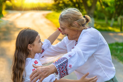 Girl embracing grandmother outdoors